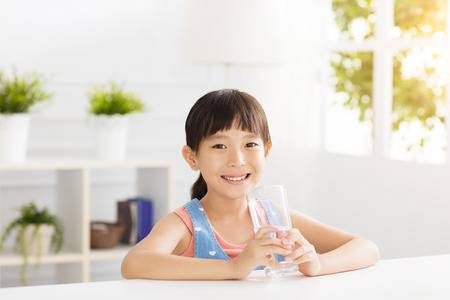Happy child drinking water from glass